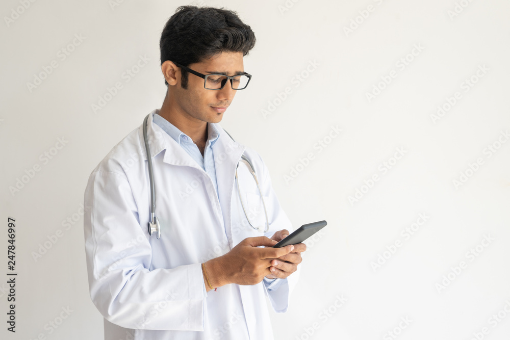 Young Indian doctor texting his patient Young Indian doctor texting his patient