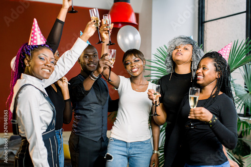 Group of happy africans friends drinking champagne and celebrating New Year. New year party. Birthday party