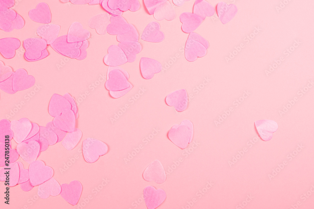 Pink background with heart-shaped confetti.