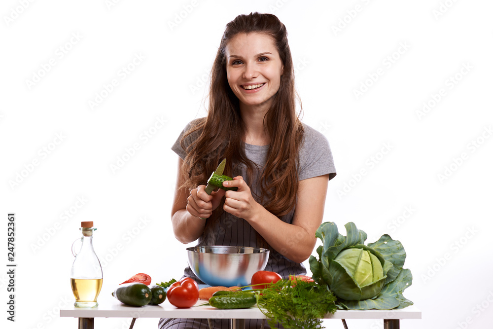 happy adult woman with various fresh vegetables on kitchen table looking at camera happy adult woman with various fresh vegetables on kitchen table looking at camera