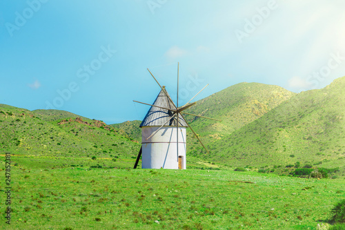 traditional windmill on the green lawn and hills
