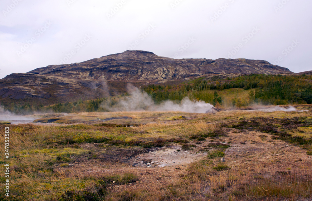 Beautiful view of the national park in the valley of Haukadalur, Iceland. View of the valley of geysers, hills and mountains, smoking sources.
