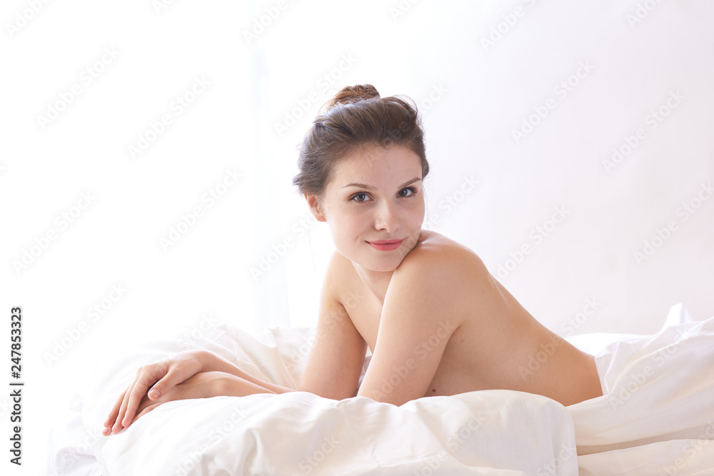 Obraz premium brunette woman lying on bed in bedroom