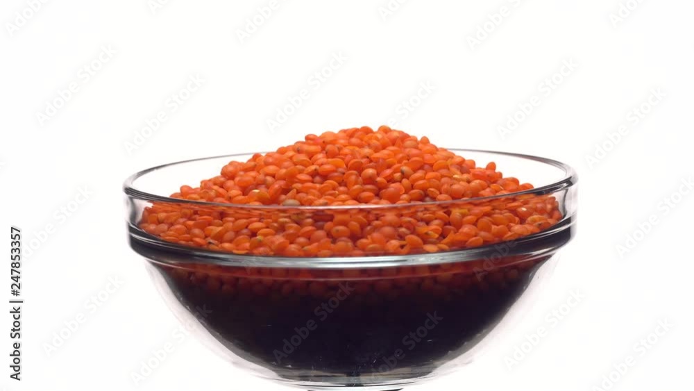 Lentils. Heap of raw uncooked red lentils in bowl in rotation. Red Chief Lentils, petite crimson lentils - Close up. Food background. isolated on white, studio shot. Healthy organic food diet concept Lentils. Heap of raw uncooked red lentils in bowl in rotation. Red Chief Lentils, petite crimson lentils - Close up. Food background. isolated on white, studio shot. Healthy organic food diet concept