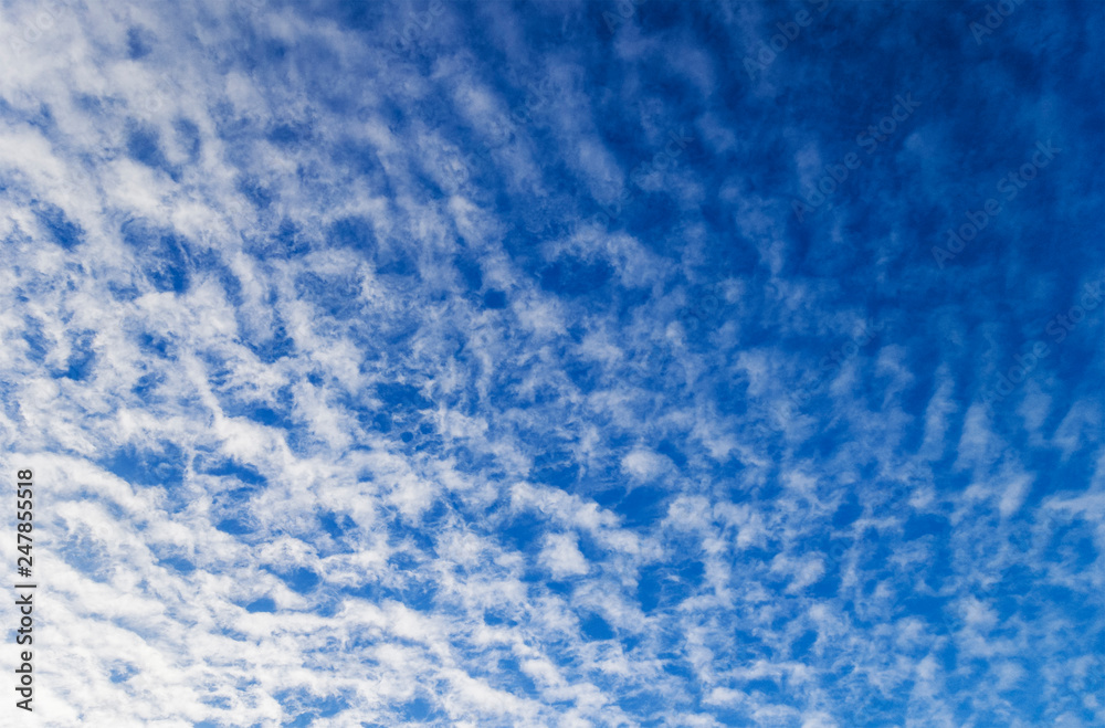 Blue sky with scattered cloud background