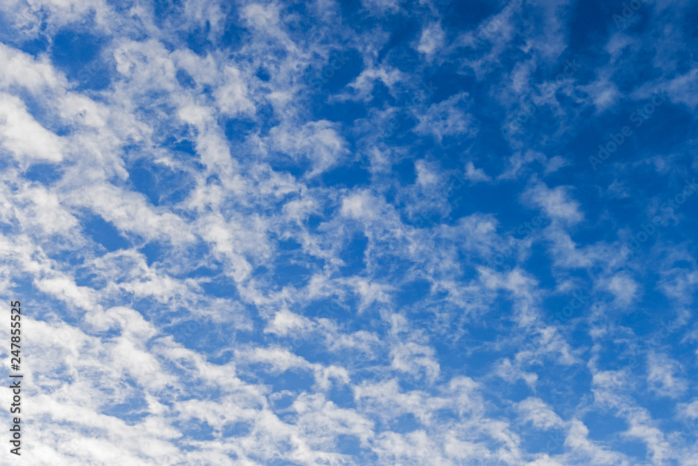 Blue sky with scattered cloud background