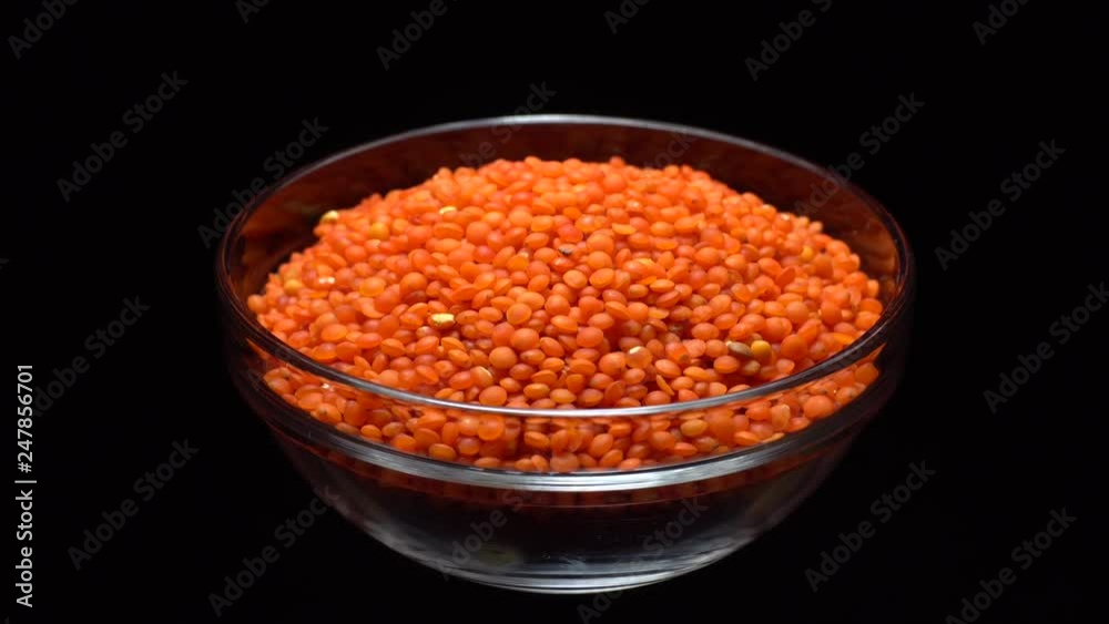 Lentils. Heap of raw uncooked red lentils in bowl in rotation. Red Chief Lentils, petite crimson lentils - Close up. Food background. black background, studio shot. Healthy organic food diet concept Lentils. Heap of raw uncooked red lentils in bowl in rotation. Red Chief Lentils, petite crimson lentils - Close up. Food background. black background, studio shot. Healthy organic food diet concept
