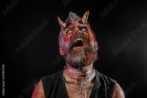 Valokuva Halloween satan face with open mouth, beard, red blood, wounds