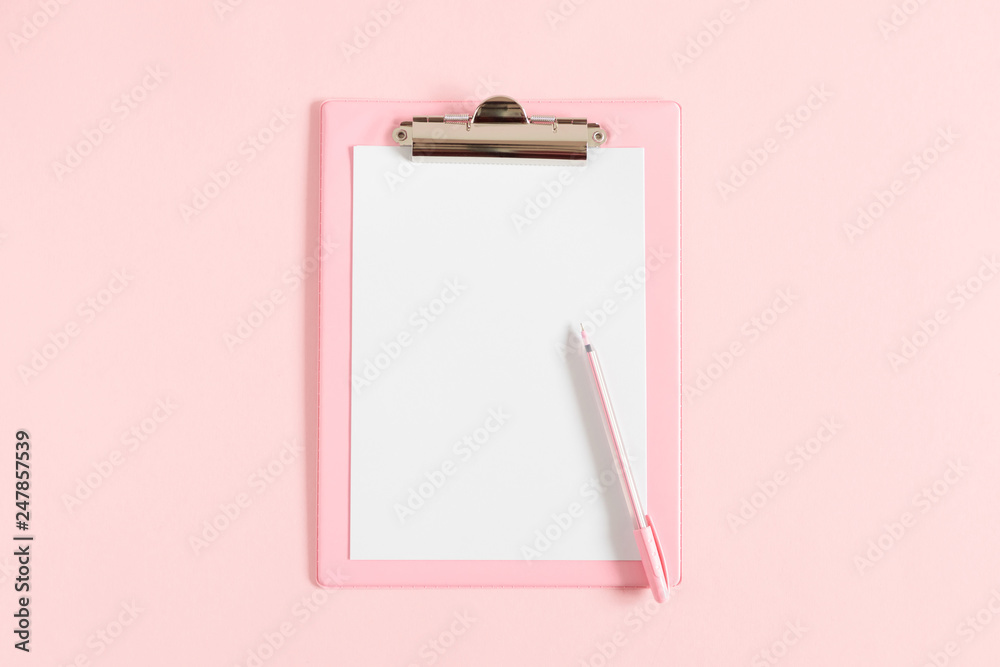 Female workspace. Office pink table, clipboard, stationery on pink
