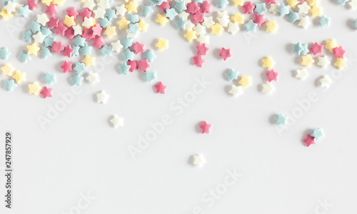 Colorful sugar sprinkles, candy, baking decorations, stars on white background. Flat lay, top view, copy space