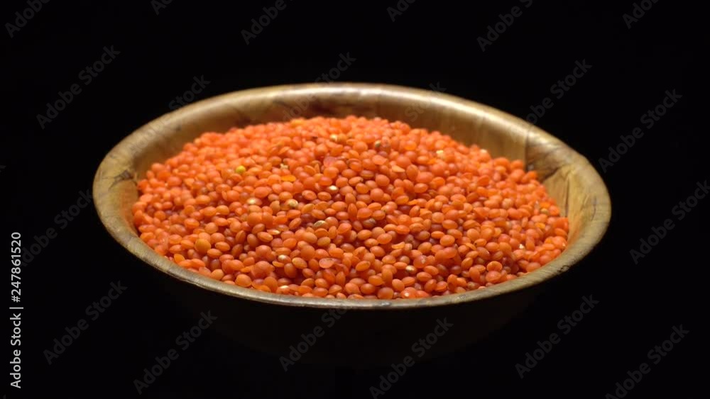 Lentils. Heap of raw uncooked red lentils in bowl in rotation. Red Chief Lentils, petite crimson lentils - Close up. Food background. black background, studio shot. Healthy organic food diet concept Lentils. Heap of raw uncooked red lentils in bowl in rotation. Red Chief Lentils, petite crimson lentils - Close up. Food background. black background, studio shot. Healthy organic food diet concept