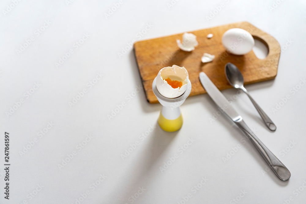 Soft boiled white eggs in egg cups on white table on wooden board. opy space, top view. Soft boiled white eggs in egg cups on white table on wooden board. opy space, top view.