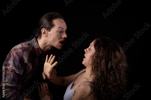 man threatening a scared woman in a gender violence case between a young couple arguing and struggling
