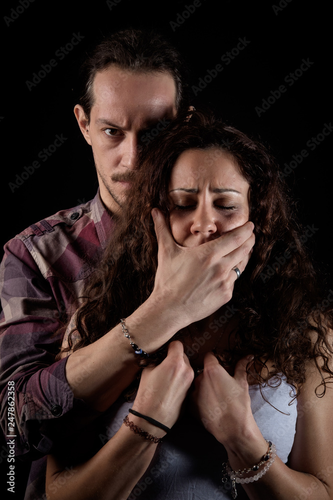 man threatening and shutting up a scared woman in a gender violence case in a young couple arguing and struggling man threatening and shutting up a scared woman in a gender violence case in a young couple arguing and struggling