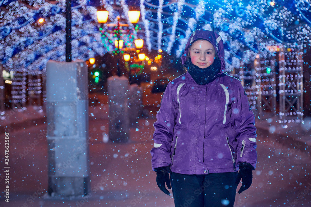 Portrait of teen girl at city skating rink with bright lights in the background in the evening Portrait of teen girl at city skating rink with bright lights in the background in the evening