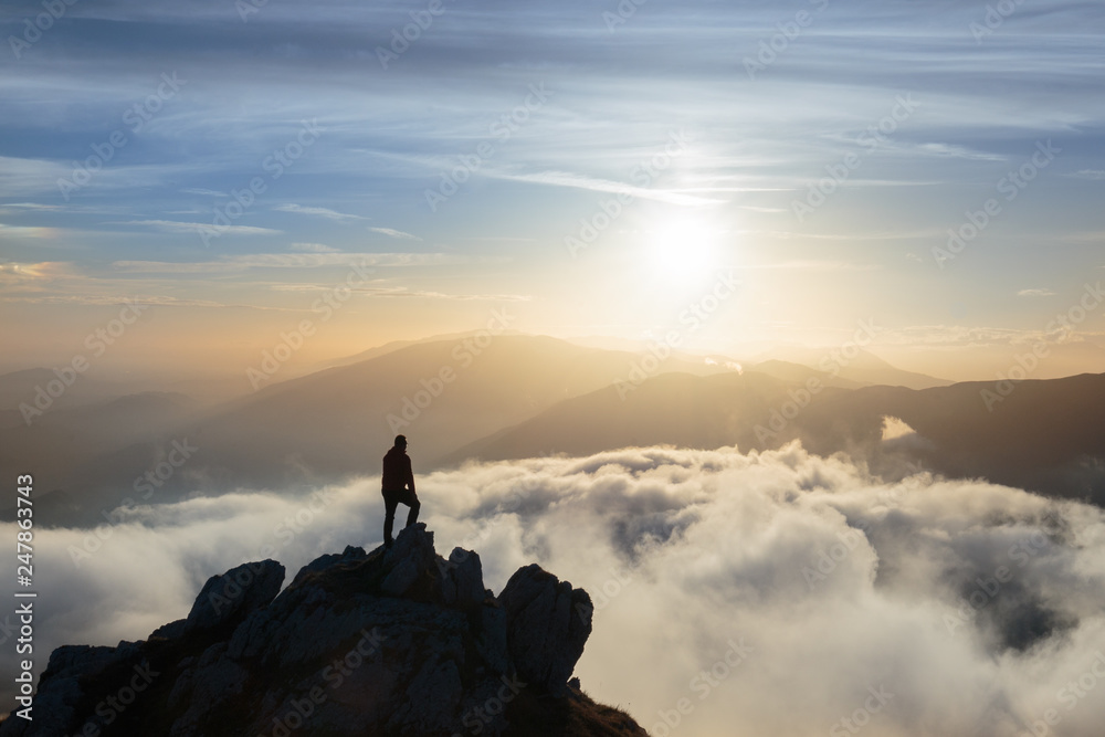 Escursionista uomo in cima alla montagna, sopra un mare di nuvole, Cansiglio, Fregona , Veneto