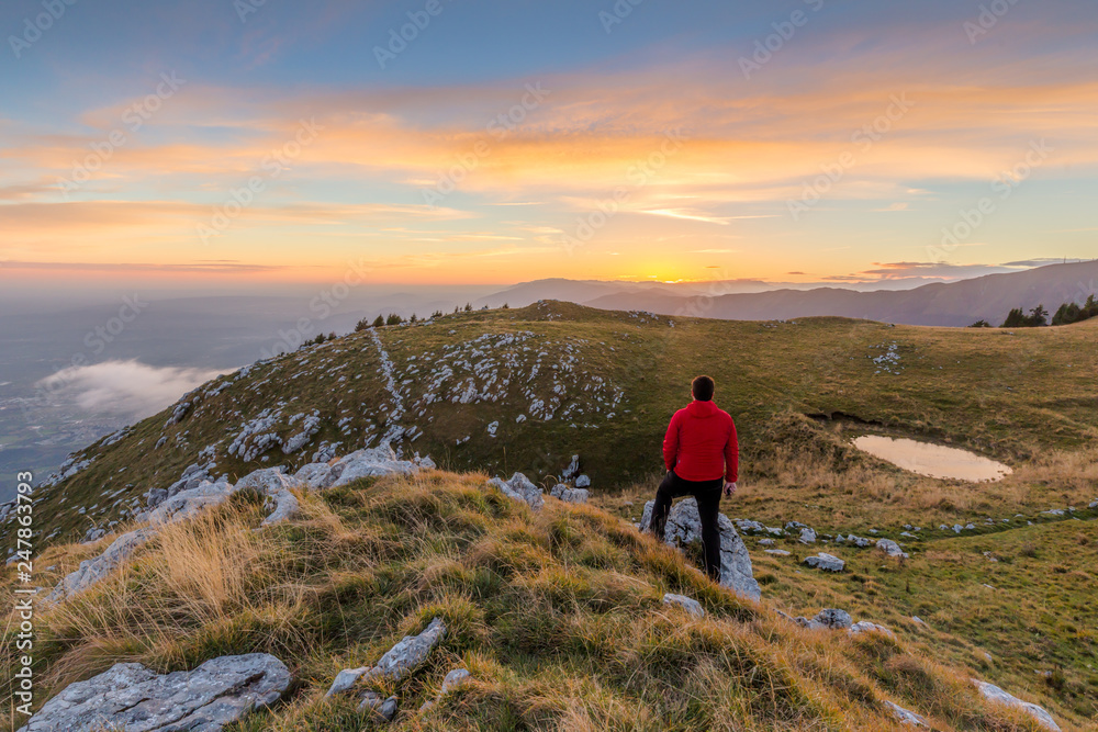 Escursionista uomo in cima alla montagna al tramonto, Cansiglio, Fregona , Veneto