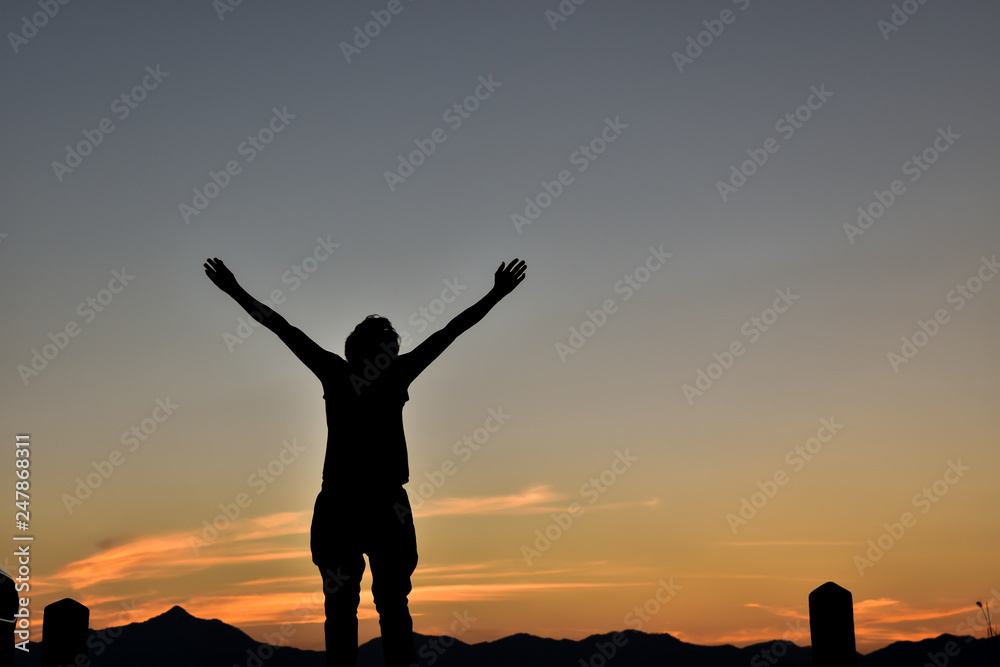 Silhouette of man open arms stay at sunset, Concept lifestyle freedom vacation travel.