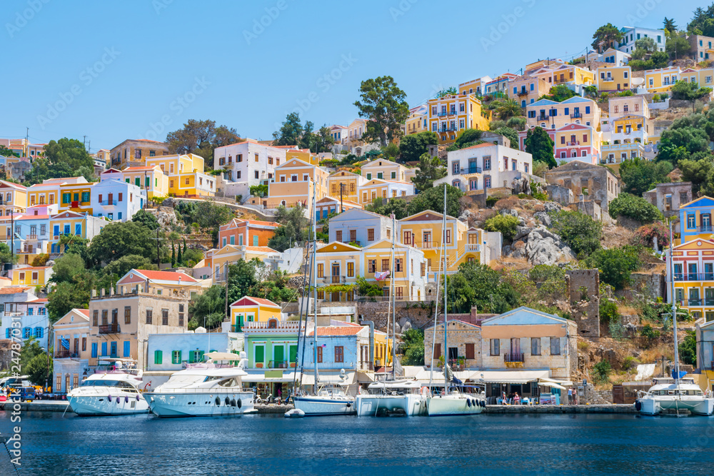 Sail boats, yachts and colorful houses in harbor town of Symi (Symi Island, Greece)
