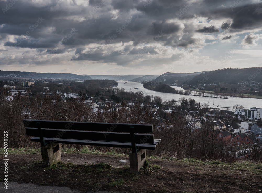 a bench sitting overlooking the river rhin in bonn,germany