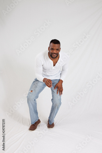 Happy black man kneeling and smiling © Allen Penton