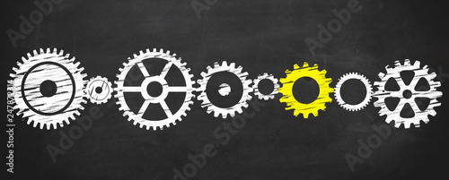 yellow gear turns all gears on blackboard photo