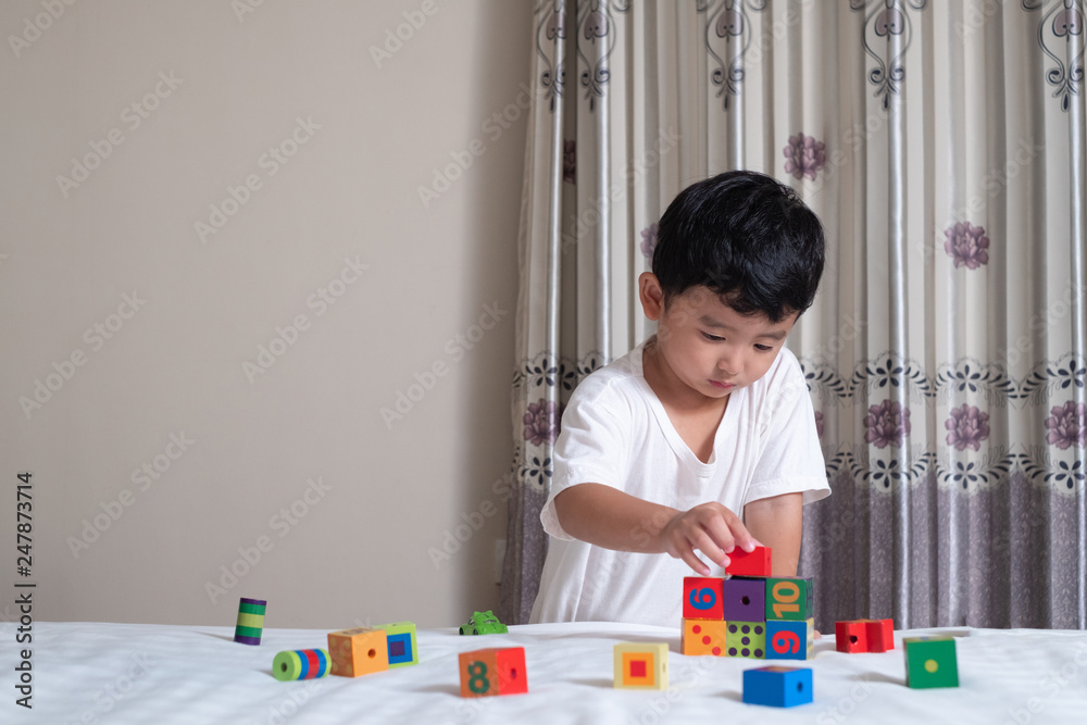 3 years old little cute Asian boy play toy or square block puzzle at home on