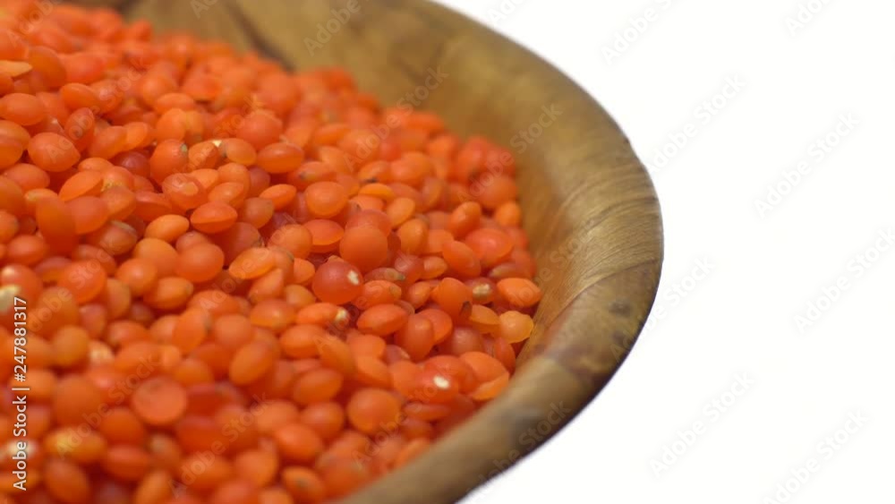 Lentils. Heap of raw uncooked red lentils in bowl in rotation. Red Chief Lentils, petite crimson lentils - Close up. Food background. isolated on white, studio shot. Healthy organic food diet concept Lentils. Heap of raw uncooked red lentils in bowl in rotation. Red Chief Lentils, petite crimson lentils - Close up. Food background. isolated on white, studio shot. Healthy organic food diet concept