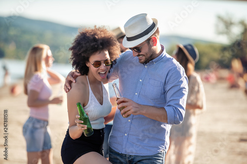 Girl and boyfriend laughing on sunny beach