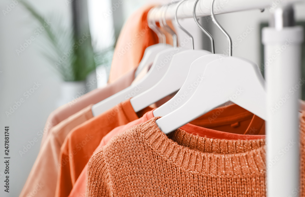 © New Africa - Hangers with orange clothes on rack, closeup © New Africa - Hangers with orange clothes on rack, closeup