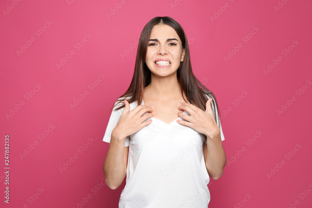 Young woman scratching chest on color background. Annoying itch Young woman scratching chest on color background. Annoying itch