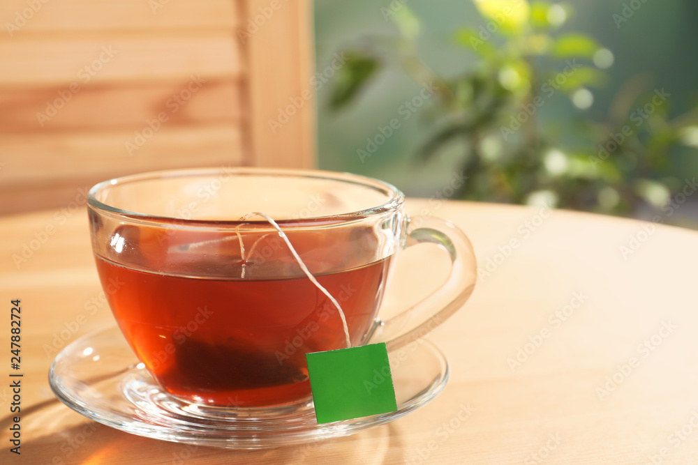 Brewing tea with bag in cup on table. Space for text Brewing tea with bag in cup on table. Space for text