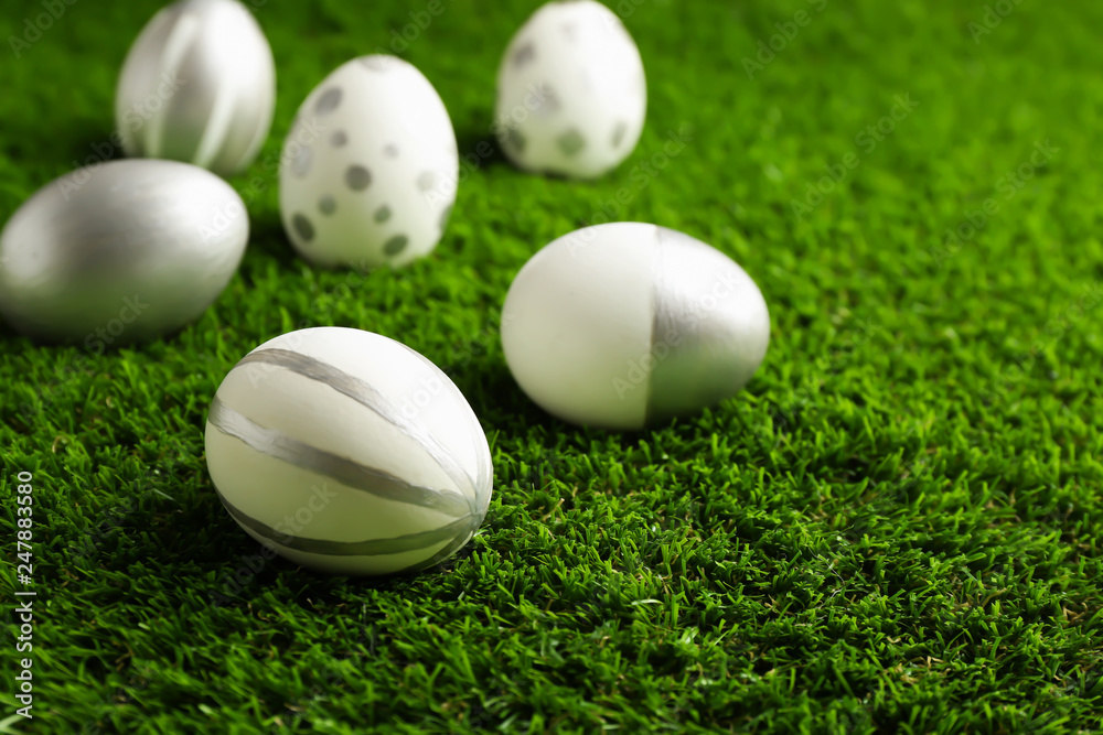 Traditional painted Easter eggs on green lawn, space for text Traditional painted Easter eggs on green lawn, space for text