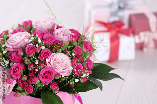 Canvas Print Beautiful bouquet of flowers and blurred gifts on background