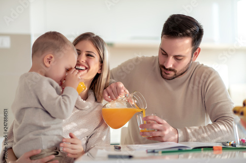 Family with child having fresh fruit juice at home