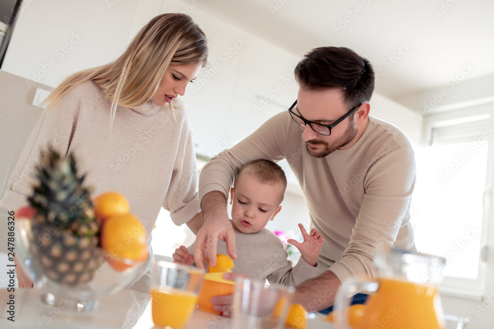 Happy family make orange juice in morning