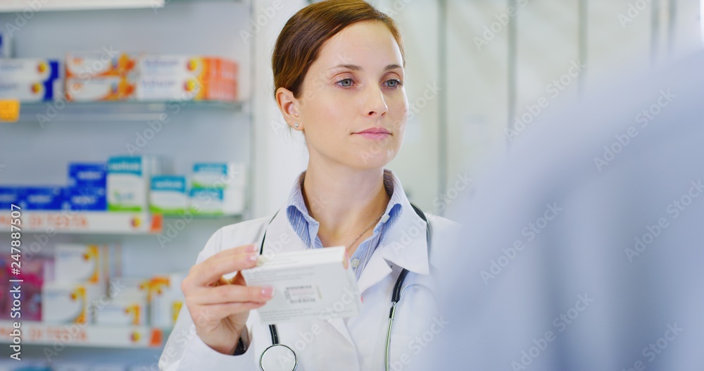 Portrait of young woman pharmacist handing over prescribed medicines to a patient in drugs store. Concept of profession, medicine and healthcare, medical education,pharmaceutical sector Portrait of young woman pharmacist handing over prescribed medicines to a patient in drugs store. Concept of profession, medicine and healthcare, medical education,pharmaceutical sector
