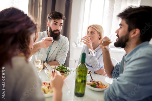 Group of friends enjoying meal at home together