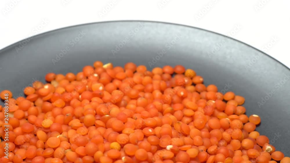 Lentils. Heap of raw uncooked red lentils in bowl in rotation. Red Chief Lentils, petite crimson lentils - Close up. Food background. isolated on white, studio shot. Healthy organic food diet concept Lentils. Heap of raw uncooked red lentils in bowl in rotation. Red Chief Lentils, petite crimson lentils - Close up. Food background. isolated on white, studio shot. Healthy organic food diet concept