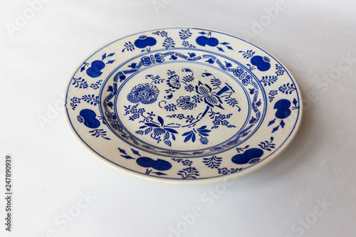 a white round plate with floral and line pattern on white background