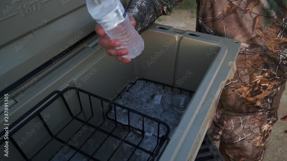 a man getting a drink out of a cooler