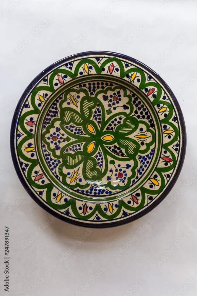 a white round plate with floral and line pattern on white background a white round plate with floral and line pattern on white background