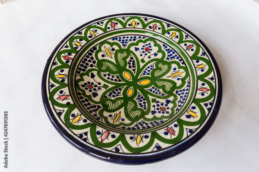 a white round plate with floral and line pattern on white background a white round plate with floral and line pattern on white background