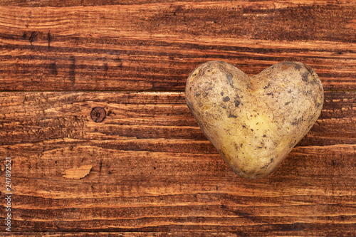 Potato heart over wooden background
