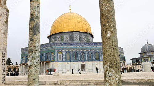 Stunning view of the beautiful Dome of the Rock with tourists taking pictures and strolling around it. The Dome of the Rock is an Islamic shrine located on the Temple Mount in Jerusalem, Israel. photo