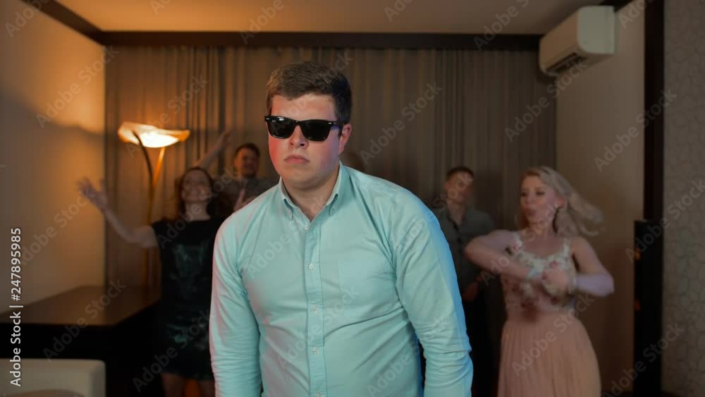Cheerful nerd male with glasses dancing and partying.