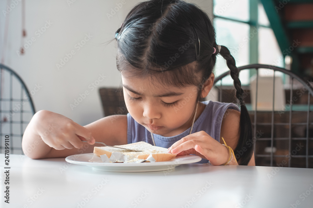 Asian children are making butter bread with knife . Asian children are making butter bread with knife .