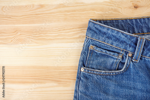 Blue jeans on wooden background.