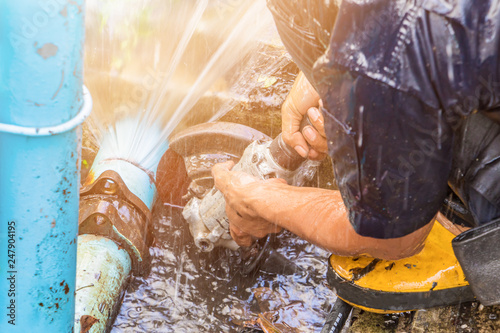 plumber working repair the broken pipe and replace   in hole with water Motion at roadside