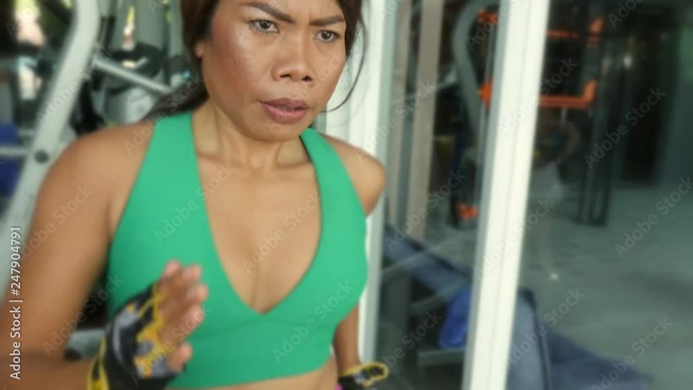 Young fit and athletic Asian Thai woman with fit body running on gym treadmill sweating training hard jogging workout in fitness and healthy lifestyle concept Young fit and athletic Asian Thai woman with fit body running on gym treadmill sweating training hard jogging workout in fitness and healthy lifestyle concept